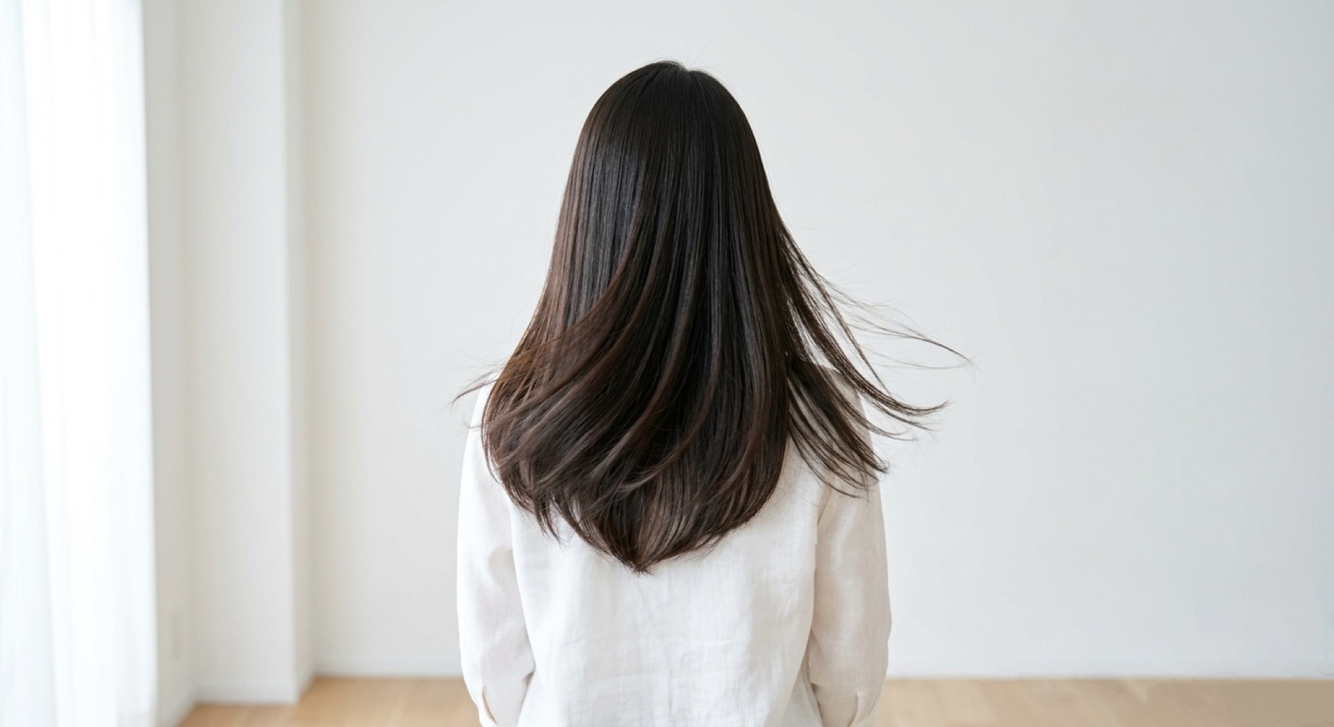 白いブラウス姿の背面から見た、艶のあるロングヘア